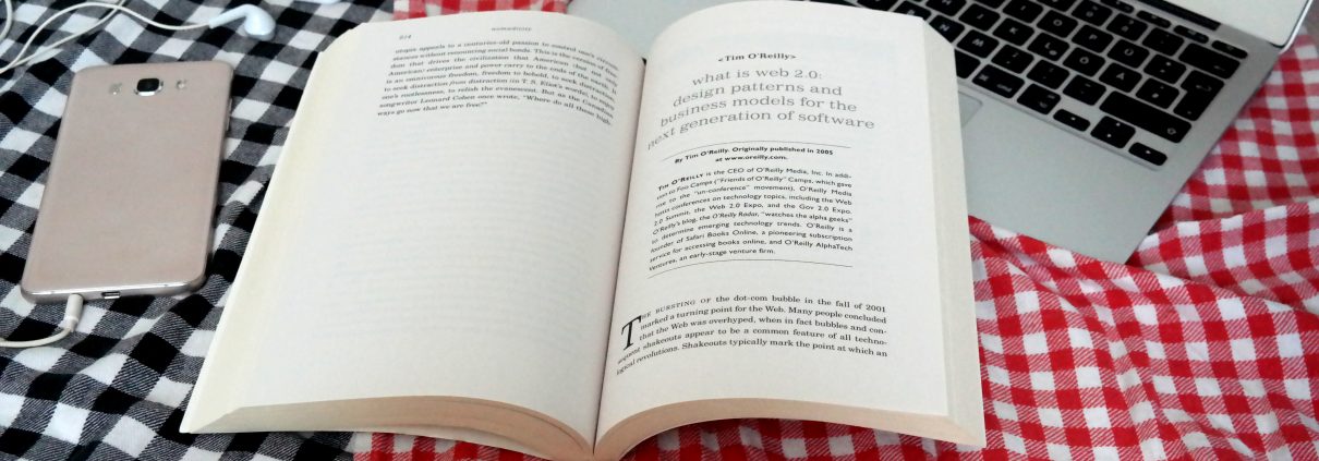 Ein aufgeschlagenes Buch auf einer Picknickdecke.