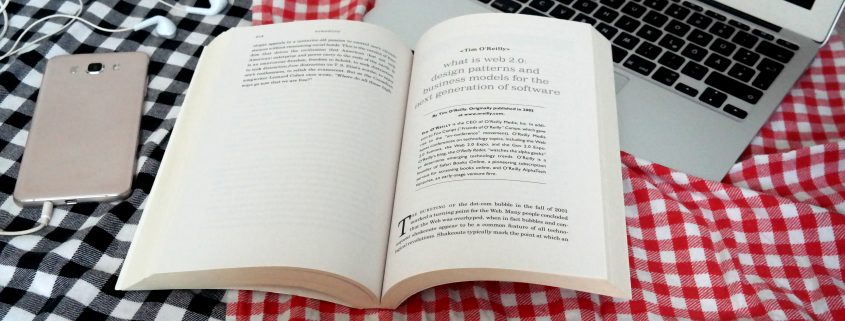 Ein aufgeschlagenes Buch auf einer Picknickdecke.